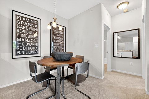 A dining room with a wooden table and chairs.