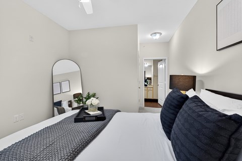 A bedroom with a large bed and a mirror on the wall.