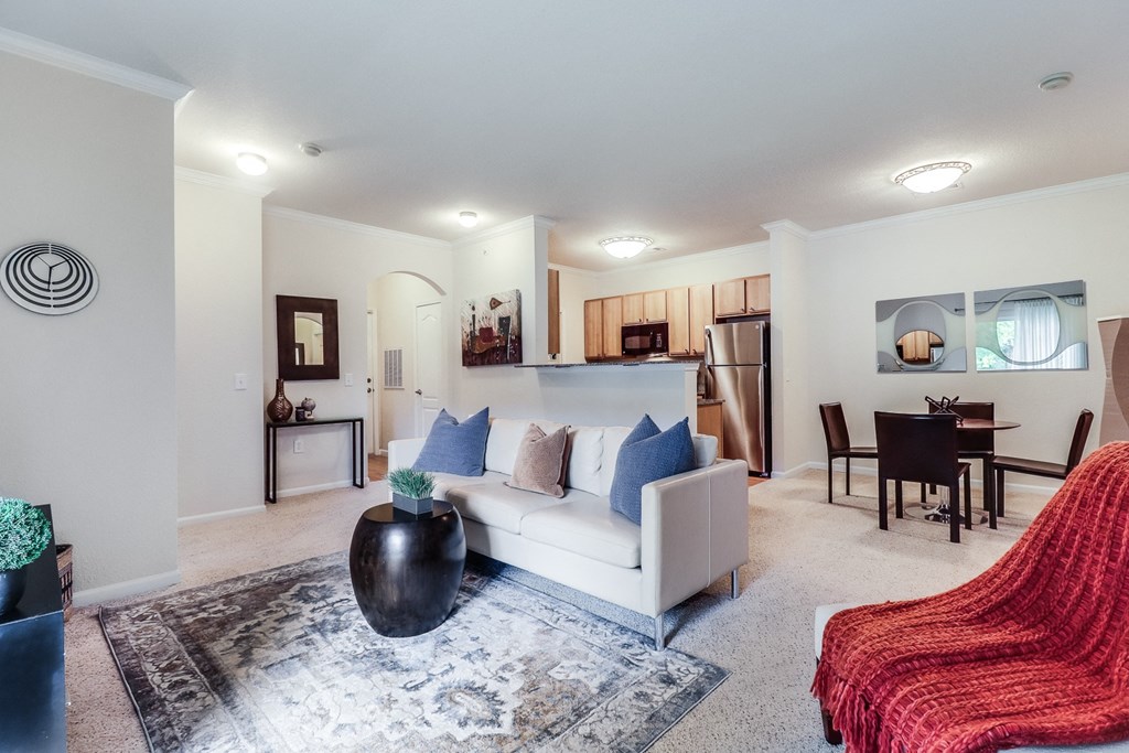 a living room with a white couch and a red chair at Plantation Crossing, Lafayette, LA, 70508