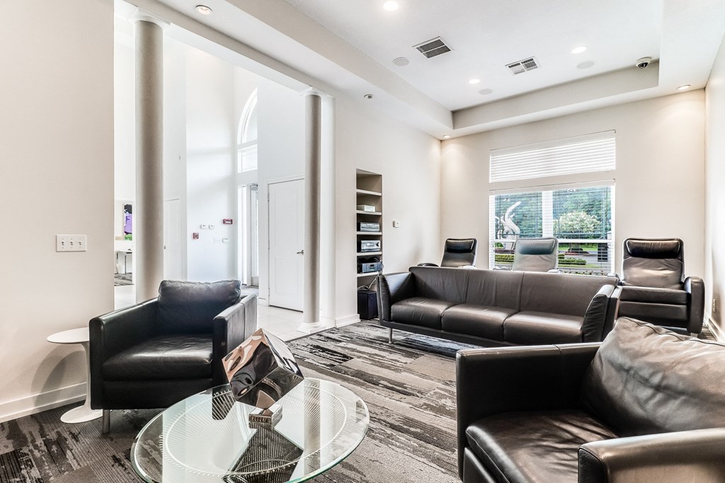 a living room with black leather couches and a glass coffee table  at Plantation Crossing, Lafayette, LA, 70508