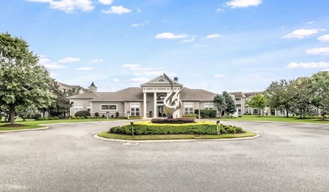 A large building with a circular driveway in front.