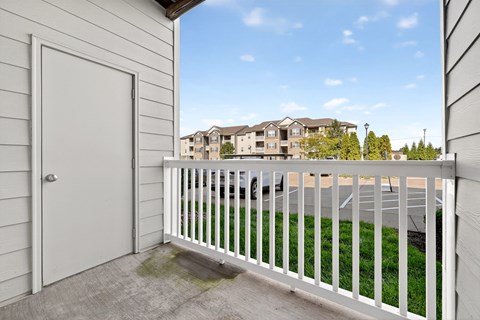 A white door is on the left of a balcony with a white railing.