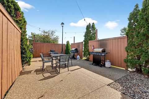 A backyard with a table and chairs.