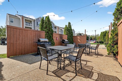 A patio with a table and chairs is set up outside a house.