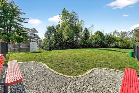 A park with a red bench and a gravel area.