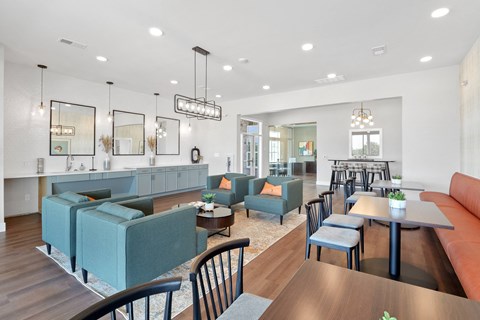 a living room with couches tables and chairs and a kitchen
