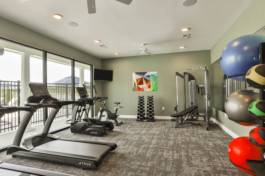 a gym with exercise equipment and a large window  at Aventura at Hawk Ridge, Missouri