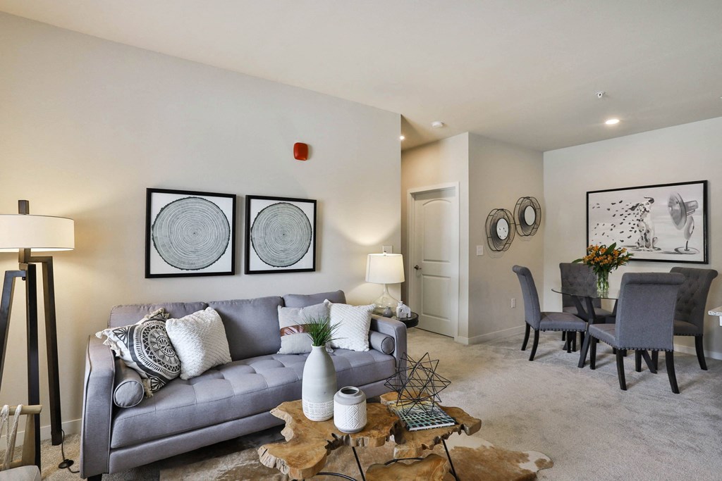 a living room and dining room with a couch and a table  at Aventura at Hawk Ridge, Lake St Louis, MO