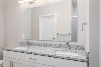 A bathroom with a granite countertop and a white door.