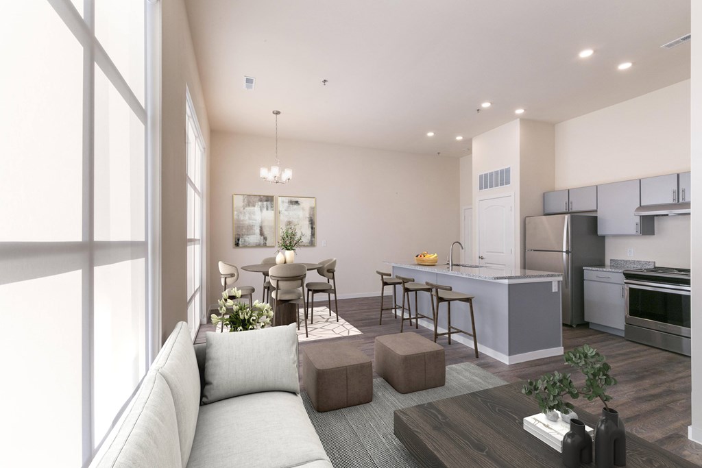 A modern kitchen and living room with a grey sofa and wooden coffee table.