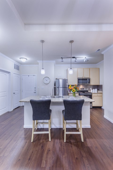 a kitchen with a large island with two chairs in front of it