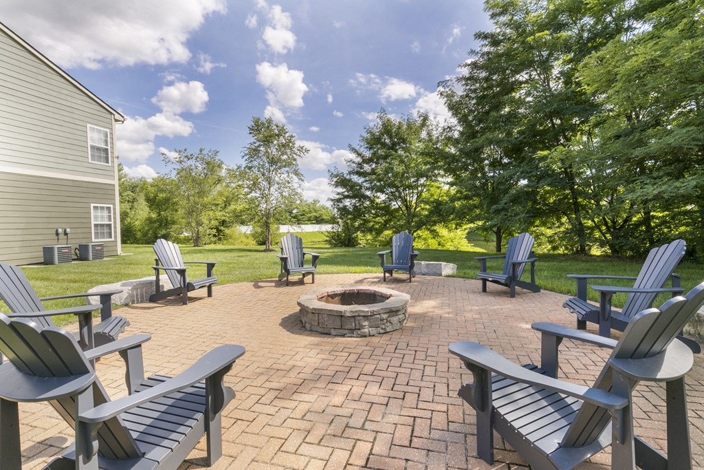 an outdoor patio with a firepit and adirondack chairs at Aventura at Richmond, St. Peters, MO, 63376