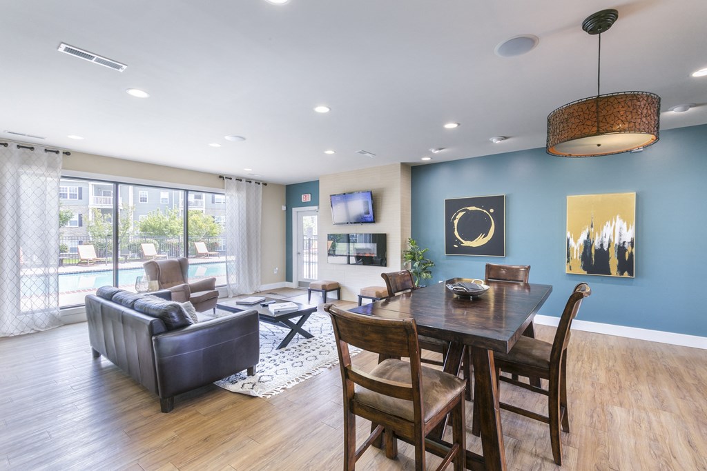 a living and dining area with a wooden table and chairs and a large window with a view at Aventura at Richmond, St. Peters, 63376