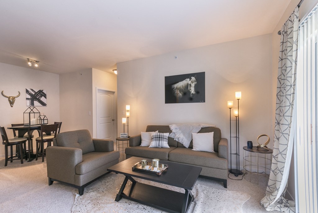 a living room with a couch and a chair and a table at Aventura at Richmond, St. Peters, MO, 63376