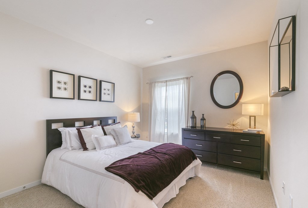 a bedroom with a bed and a dresser  at Aventura at Richmond, St. Peters, MO, 63376