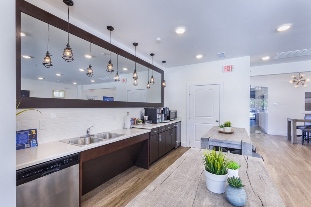 a kitchen with stainless steel appliances and a communal table at Aventura at Towne Centre, Ellisville