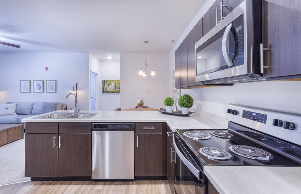 a kitchen with stainless steel appliances and a stove and a microwave at Aventura at Towne Centre, Ellisville, MO