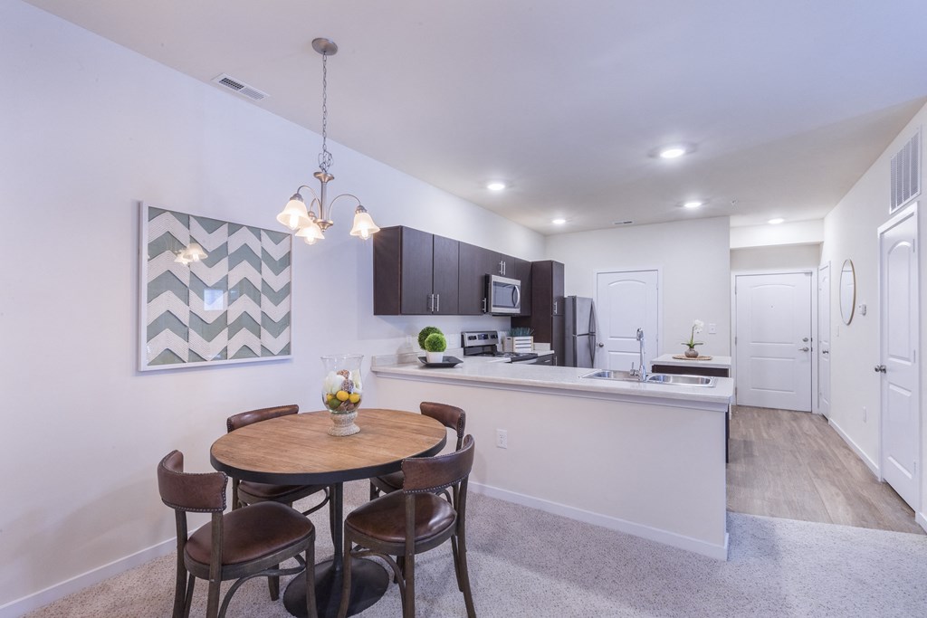 a dining room with a table and chairs next to a kitchen at Aventura at Towne Centre, Ellisville, Missouri
