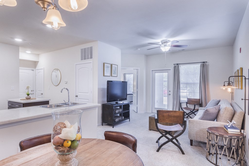 a living room with a dining room table and a television at Aventura at Towne Centre, Ellisville, MO, 63011