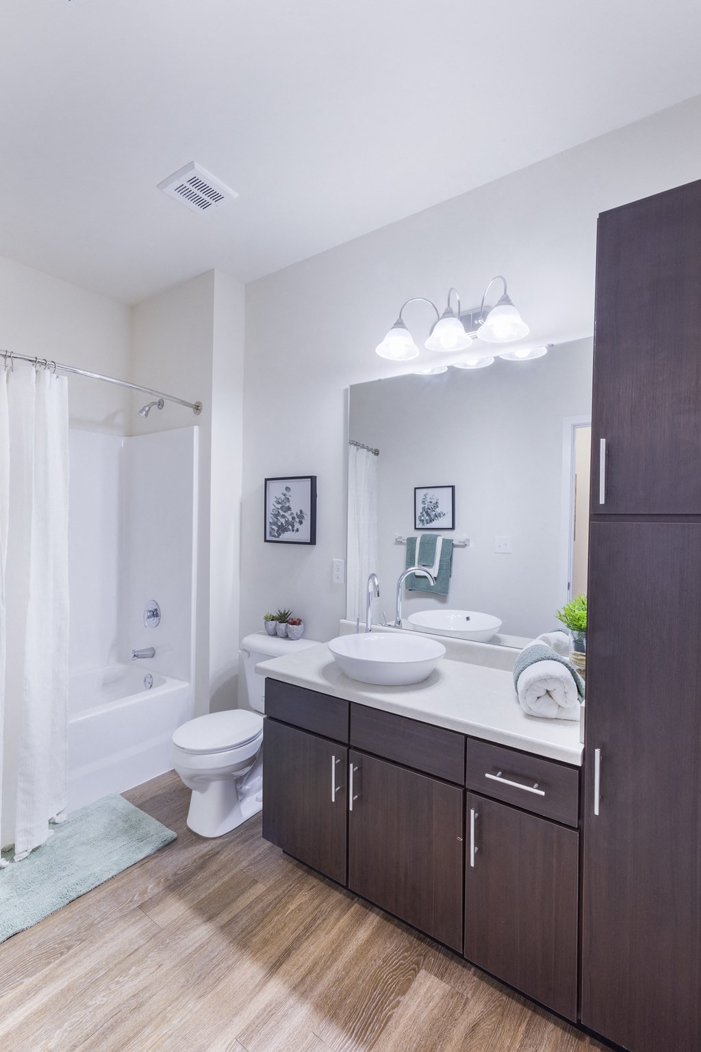 a bathroom with a toilet sink and shower and a mirror at Aventura at Towne Centre, Missouri
