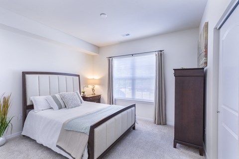 a bedroom with a bed and a dresser and a window