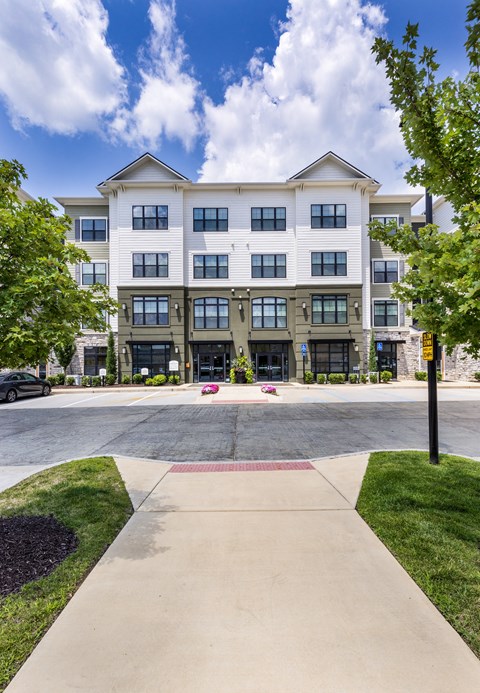 a large apartment building with a sidewalk in front of it at Aventura at Wild Horse Creek, Chesterfield, Missouri