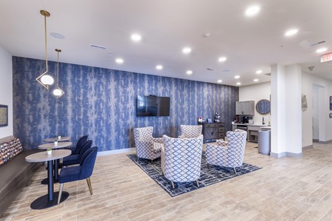 a lobby with chairs and tables and a television at Aventura at Wild Horse Creek, Chesterfield, 63017