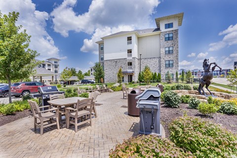 an outdoor patio with a table and chairs and a statue at Aventura at Wild Horse Creek, Missouri, 63017