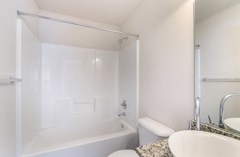 a bathroom with a tub and a sink and a toilet