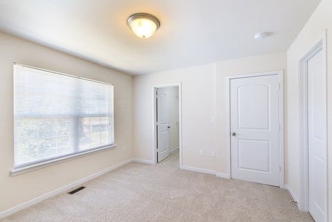 an empty room with a large window and a white door