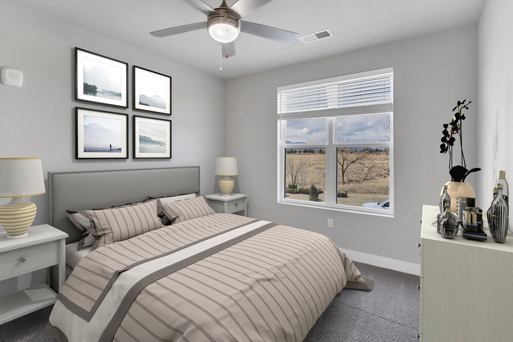 a bedroom with a large window and a ceiling fan  at The Edison at Chapel Hills, Colorado