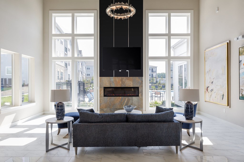 a living room with a fireplace and a large window at The Edison at Blue Springs, Blue Springs Missouri