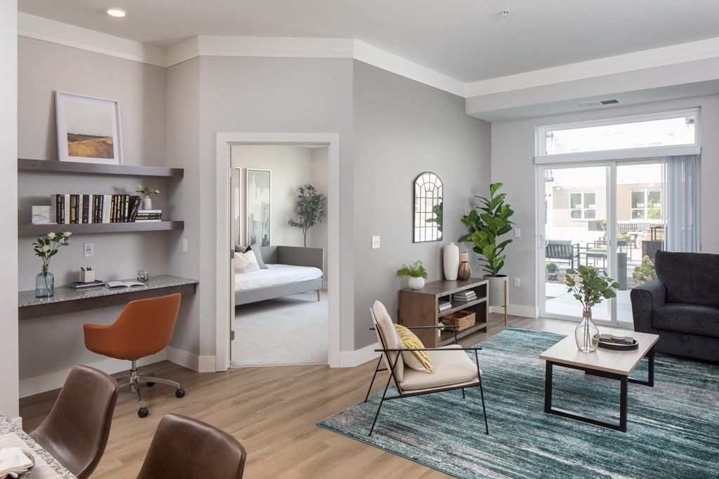 a living room with gray walls and a door that leads to a bedroom at The Edison at Rice Creek, Shoreview, Minnesota