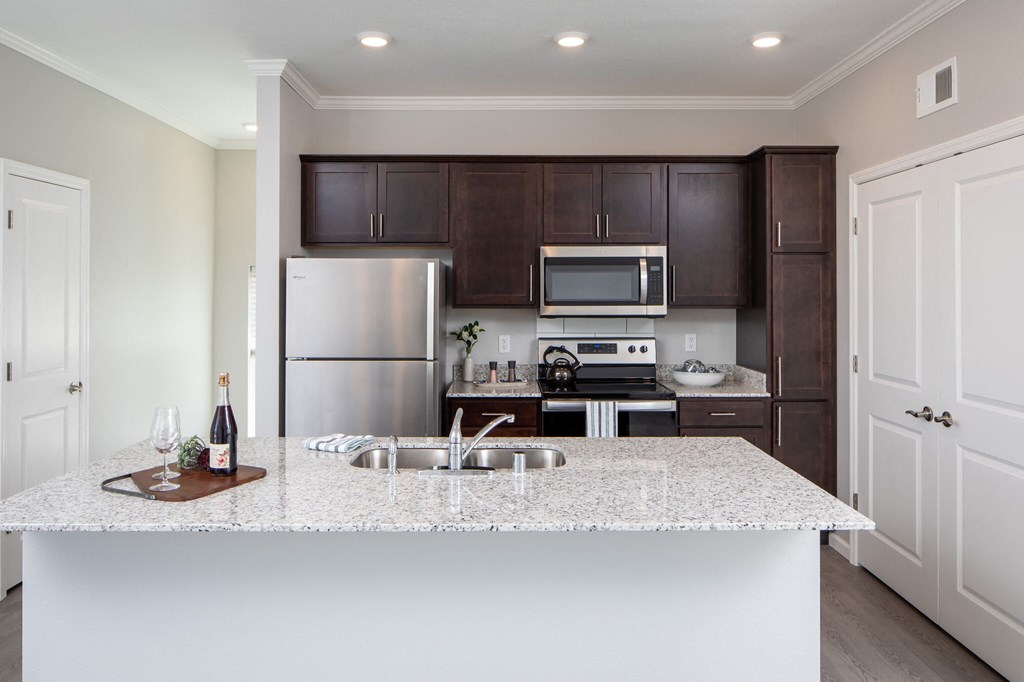 a kitchen with a large island and stainless steel appliances at The Edison at Rice Creek, Minnesota
