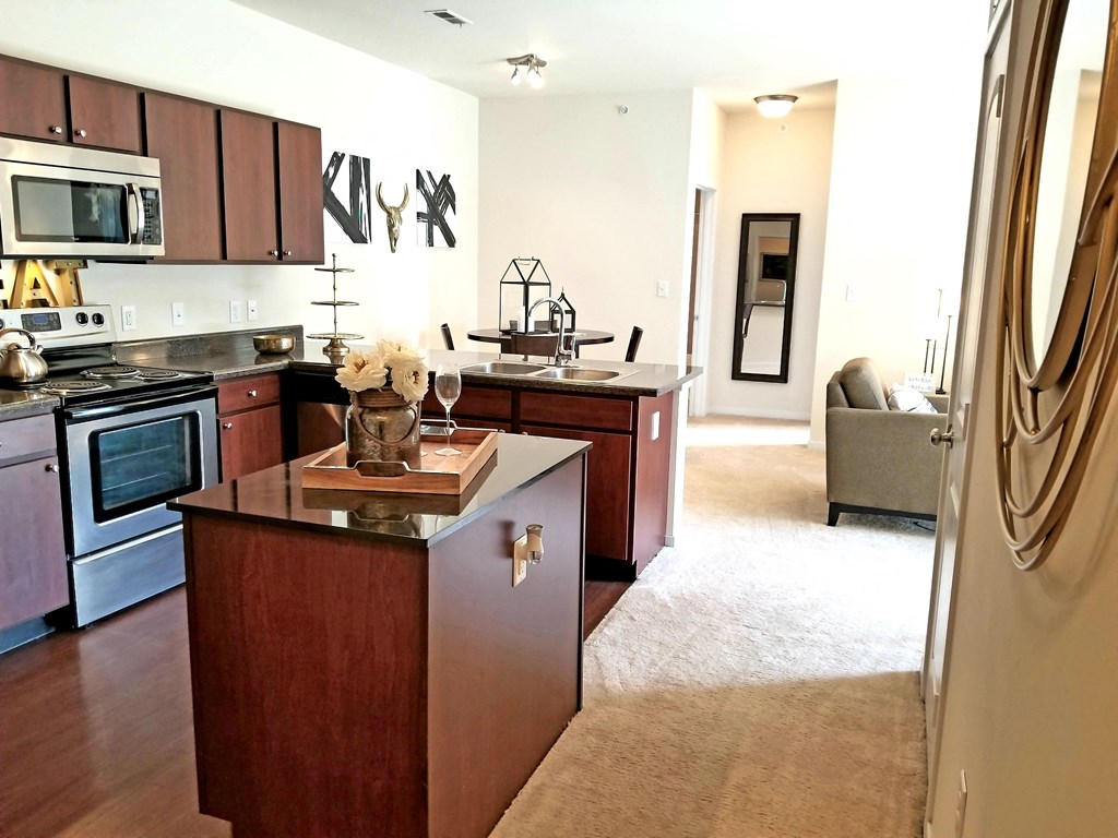a kitchen with a center island and a living room  at Aventura at Richmond, St. Peters