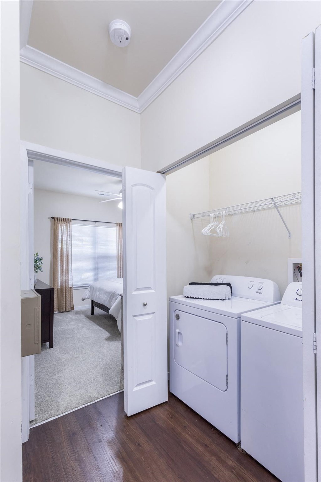 a laundry room with a washer and dryer and a bedroom with a bed