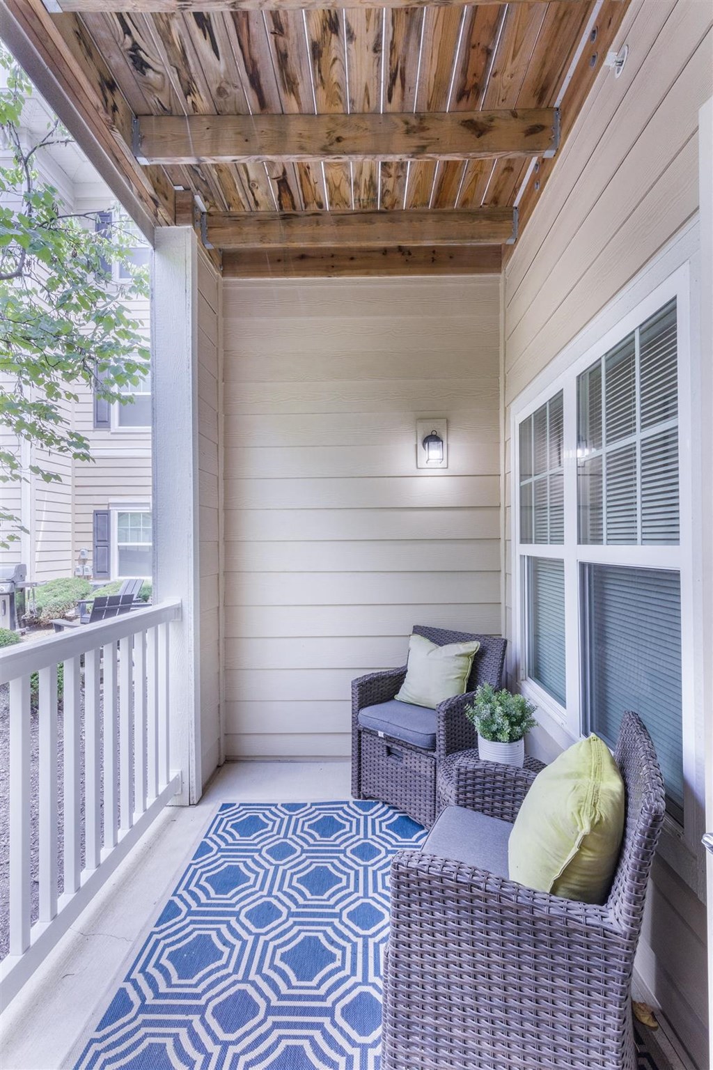 a covered porch with wicker furniture and a wooden ceiling