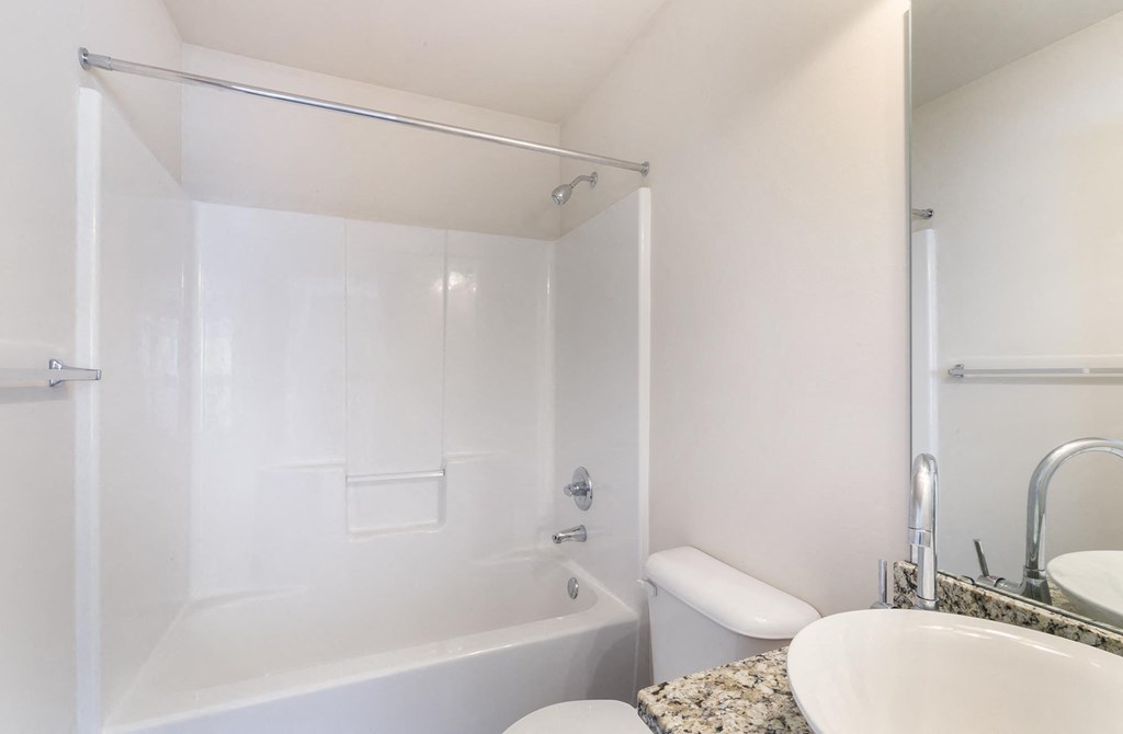 a white bathroom with a tub and a sink