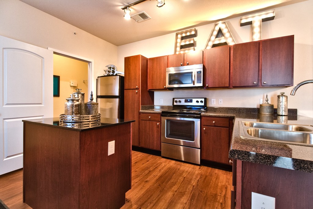 a kitchen with wooden cabinets and stainless steel appliances  at Aventura at Mid Rivers, St. Charles, 63304