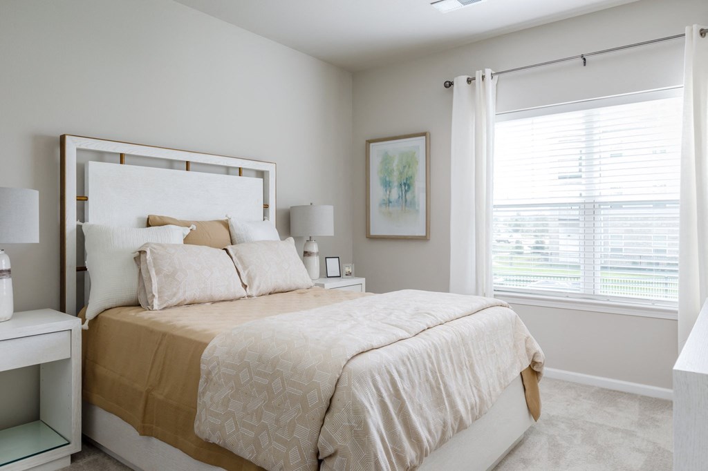 a bedroom with a bed and a window at The Edison at Blue Springs, Blue Springs, MO