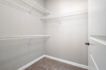 an empty closet with white walls and a white door  at Aventura at Hawk Ridge, Lake St Louis