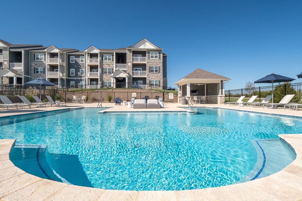 a swimming pool with an apartment building in the background  at Aventura at Hawk Ridge, Lake St Louis
