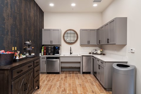 A kitchen with wooden cabinets and a round mirror above the sink.