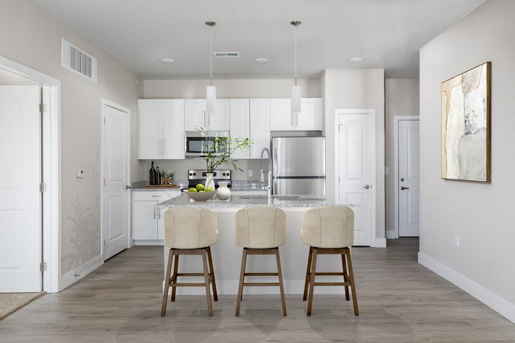 a kitchen with white cabinets and a marble counter top at The Edison at Maple Grove, Maple Grove