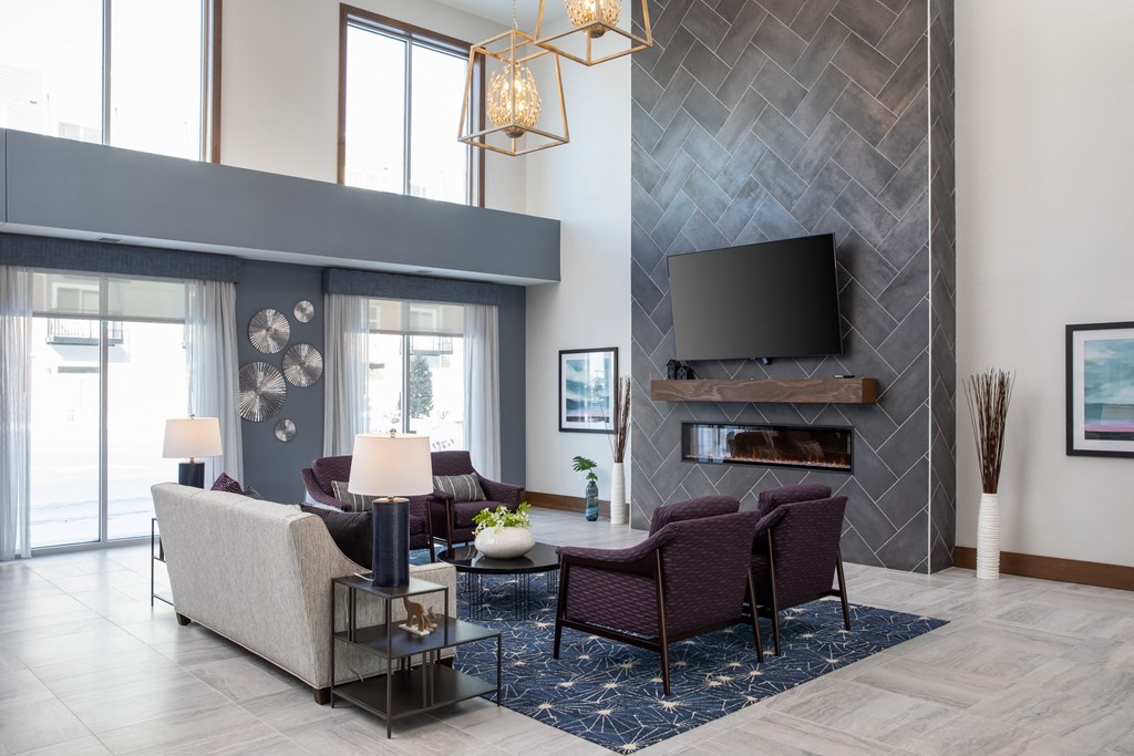 a living room with a fireplace and a large window  at The Edison at Spirit, Lakeville, MN