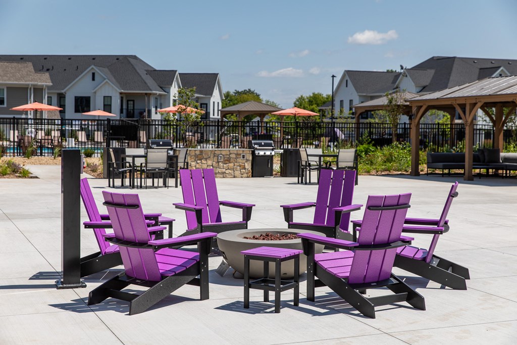 a fire pit with purple chairs and umbrellas  at The Edison at Woodbury, Minnesota, 55129