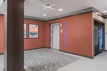 a lobby with elevators and a mural on the wall