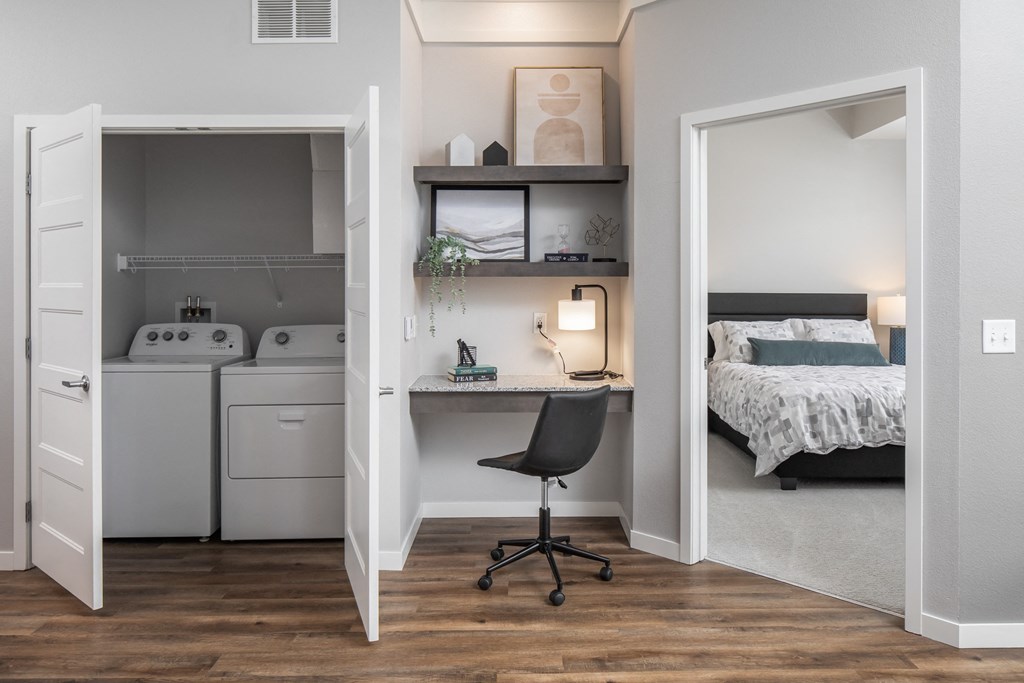 a bedroom with a desk and a washer and dryer  at The Edison at Woodbury, Minnesota, 55129