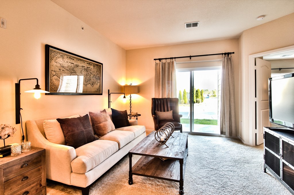 the living room of a house with a couch and a coffee table  at Aventura at Mid Rivers, St. Charles, Missouri