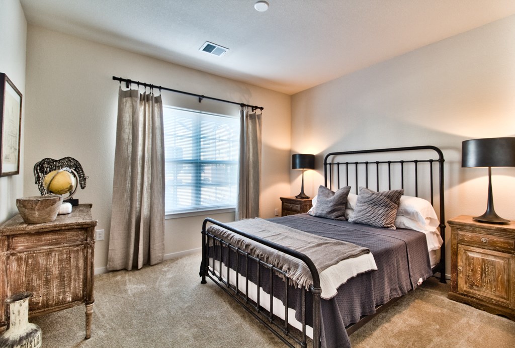 the master bedroom has a wrought iron bed and a large window  at Aventura at Mid Rivers, St. Charles, MO